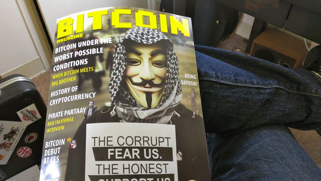 Una revista Bitcoin Magazine y en la tapa se ve una persona con la máscara de V de Vendetta 