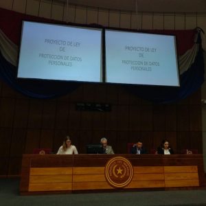 fotoestelle una mujer y tres hombres sentados en el estrado de la cámara de senadores